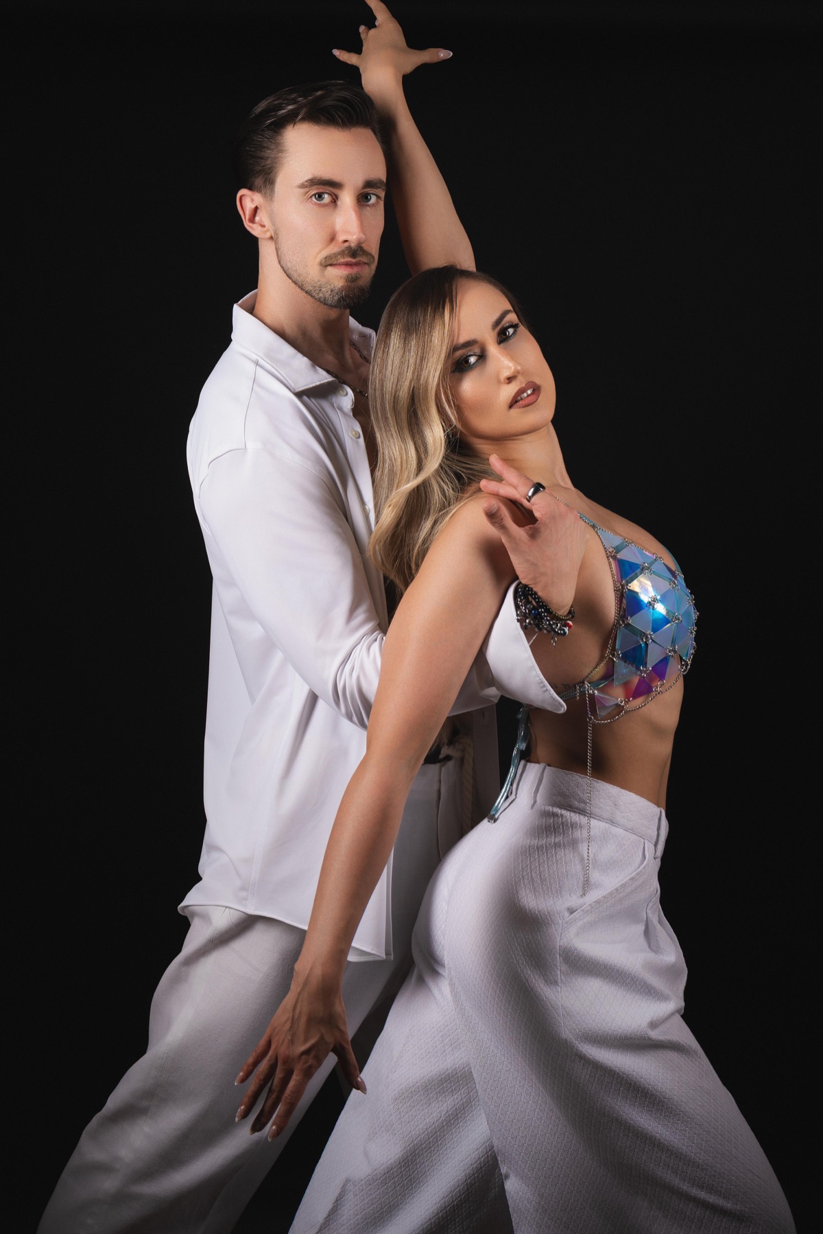 Borja y Estefanía Martínez bailando juntos sobre fondo negro, vestidos de blanco
